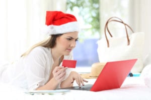 woman with santa hat on laptop