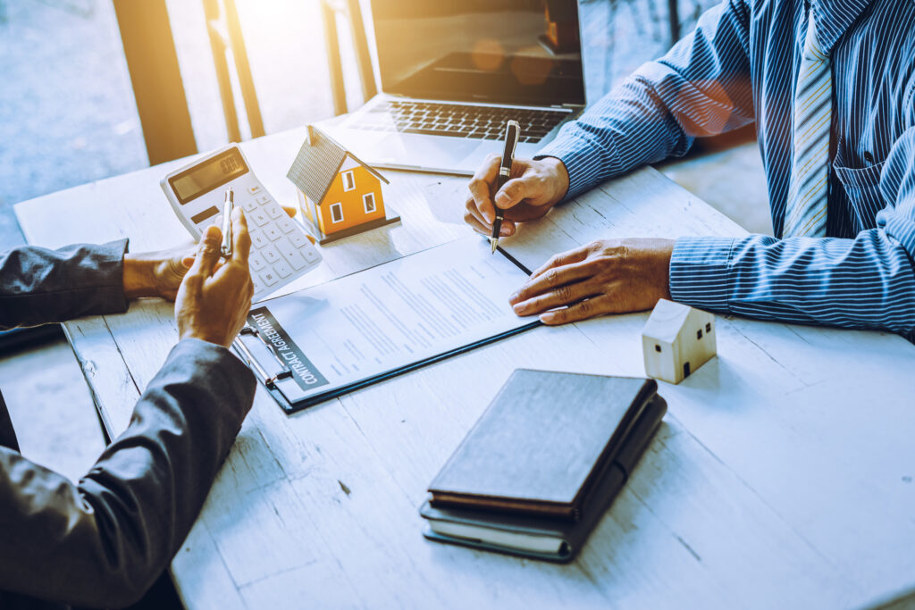 Real-estate agent sign for home contract property for sale in the office with buyer.