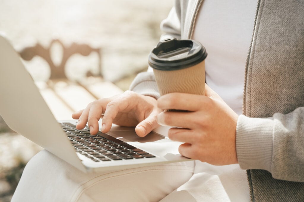 Person using a laptop, illustrating payoff wire fraud prevention and secure payoff verification for title companies